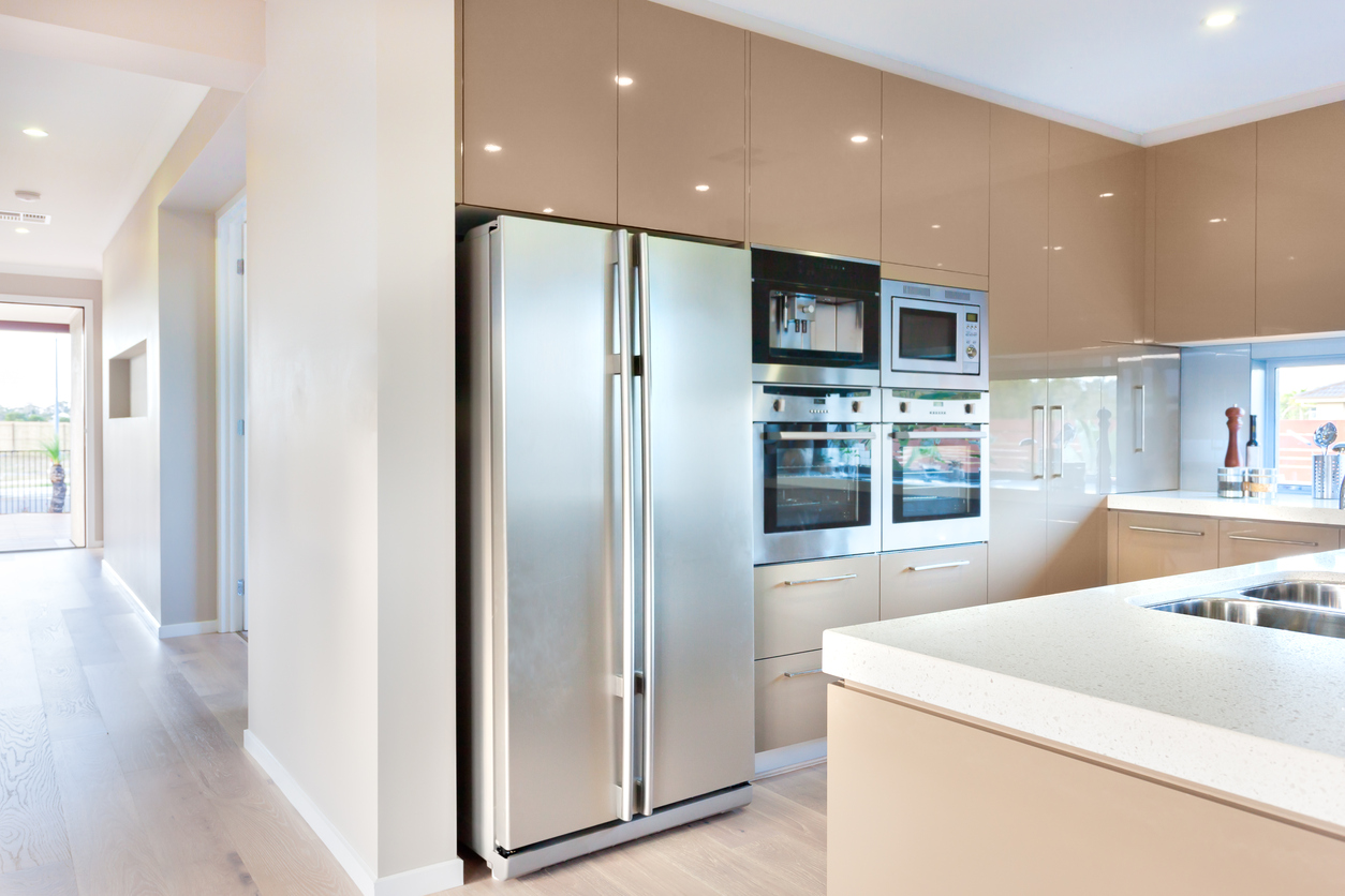 Bright kitchen with large island and stainless steel refrigerator